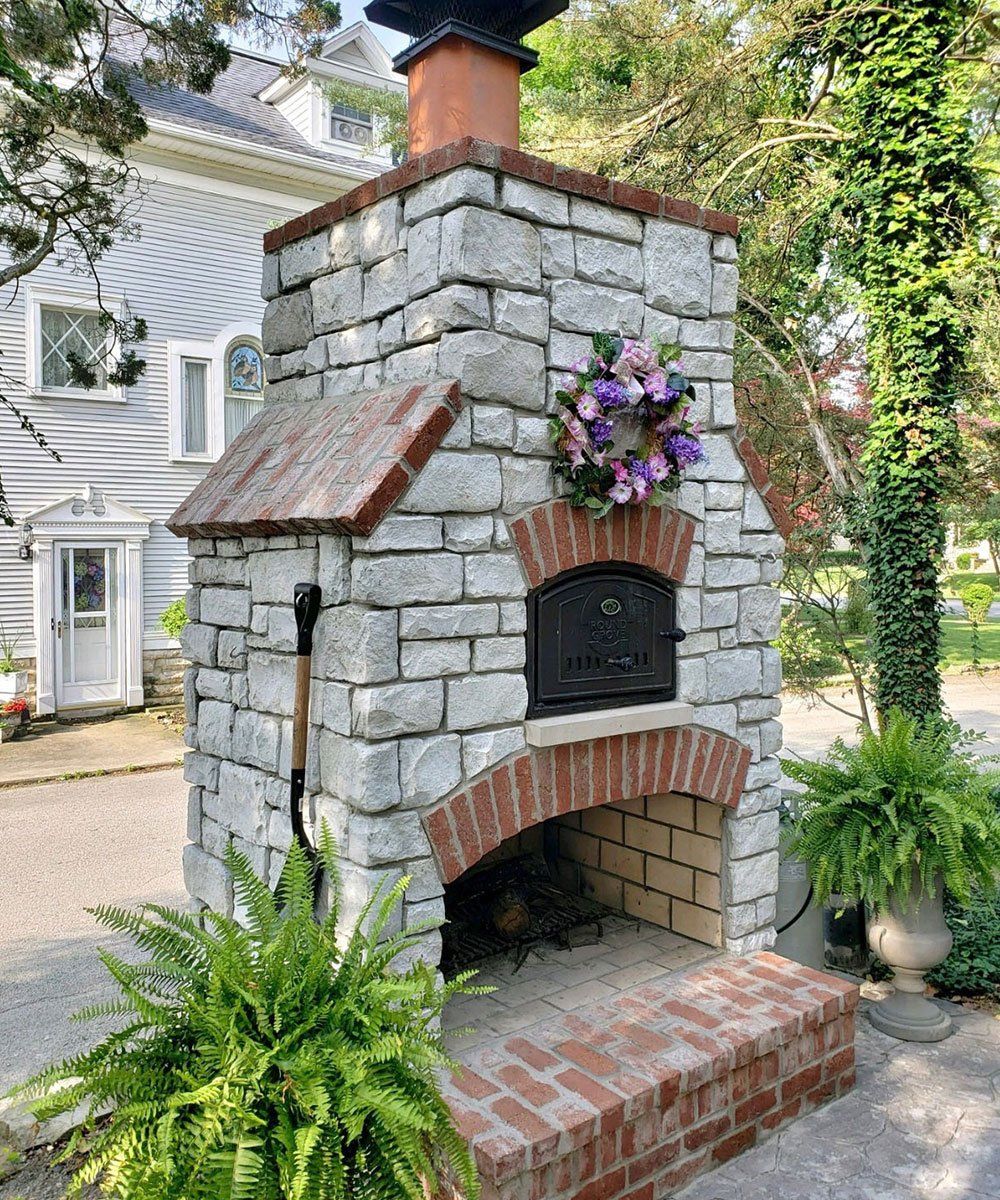 Huron, Ohio backyard stone fireplace with brick and pizza oven