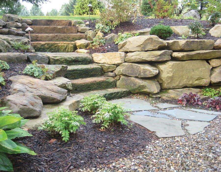 Mayfield Ohio home with exterior barnstone outcropping garden wall and natural stone steps