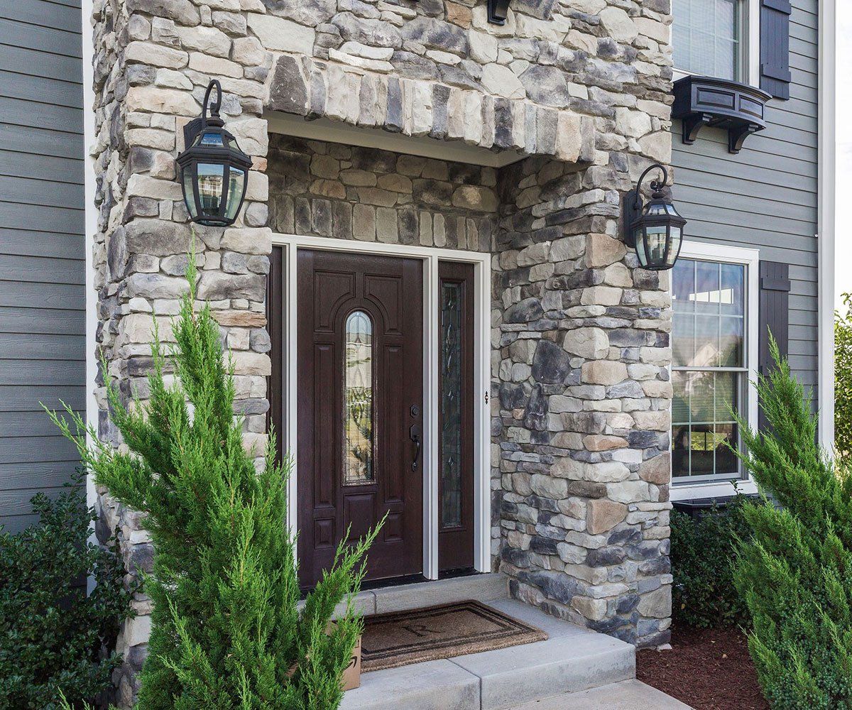 Ohio home with exterior entryway limestone faux stone veneer siding