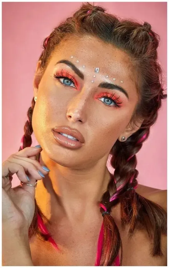 A close up of a woman 's face with makeup and long eyelash extensions.