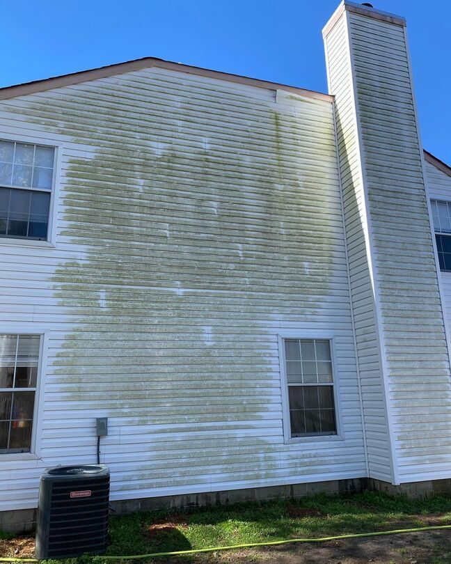 White clapboard house exterior with a tall chimney and blue sky background
