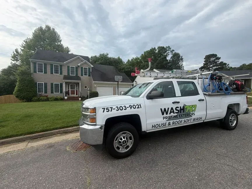 White WASH service truck parked on a suburban street in front of a house