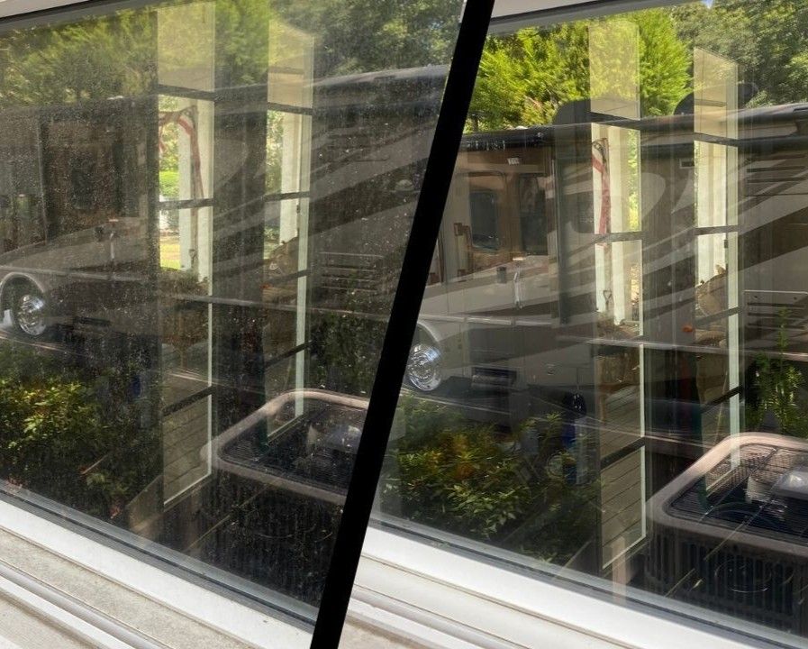 Reflective window view of a leafy street and parked cars, split by a diagonal black window frame