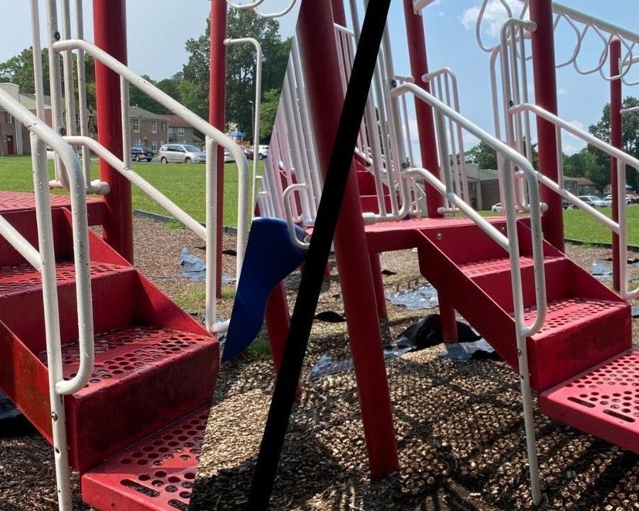 Red playground stairs and railings with a blue slide on a gravel play area