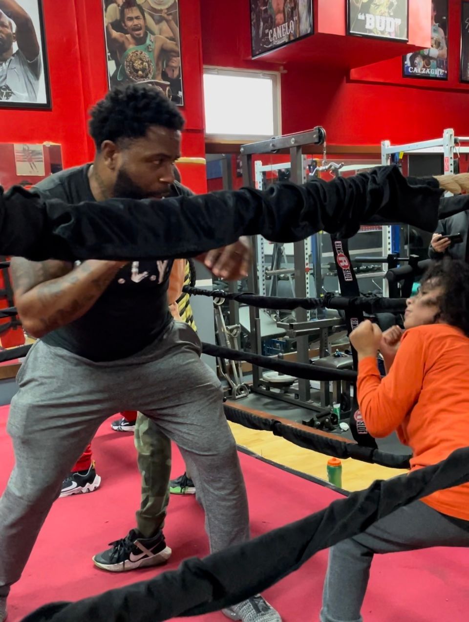 A man and a woman are boxing in a gym