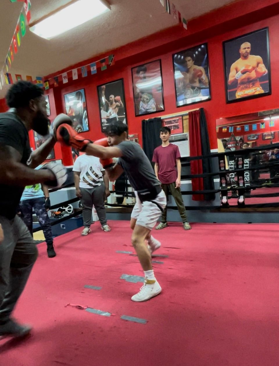 A group of men are boxing in a gym.