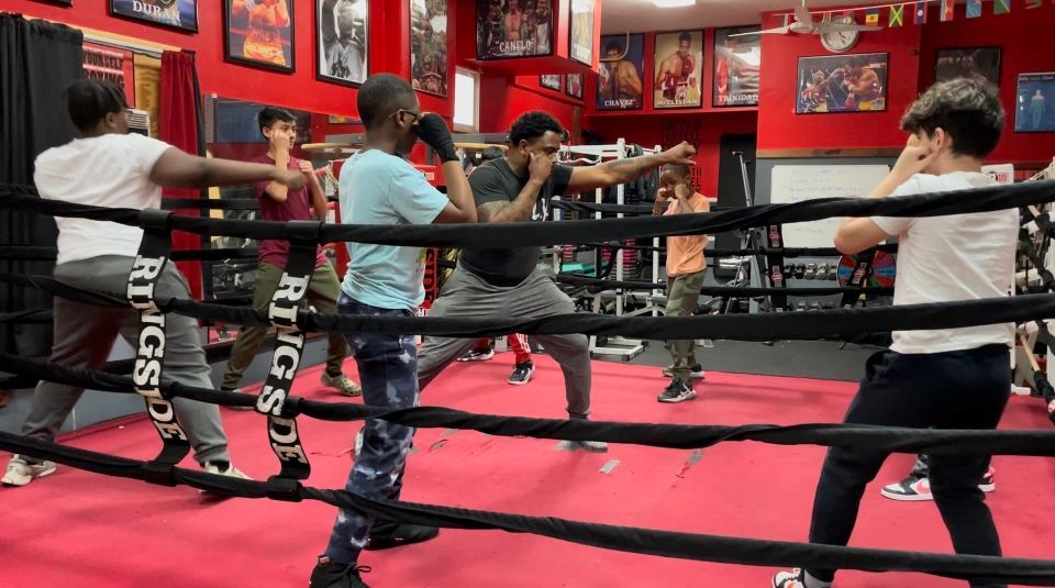 A group of young men are boxing in a boxing ring.