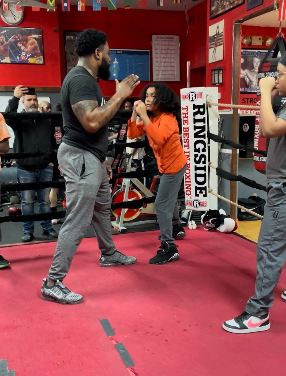 A group of people are boxing in a gym with a sign that says ringside