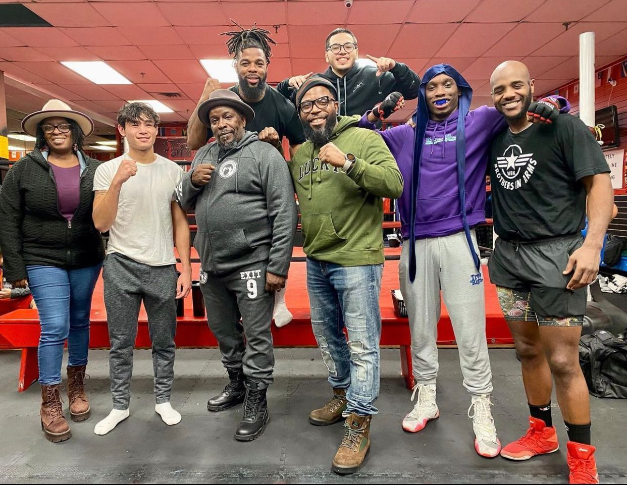 A group of people are posing for a picture in a gym.