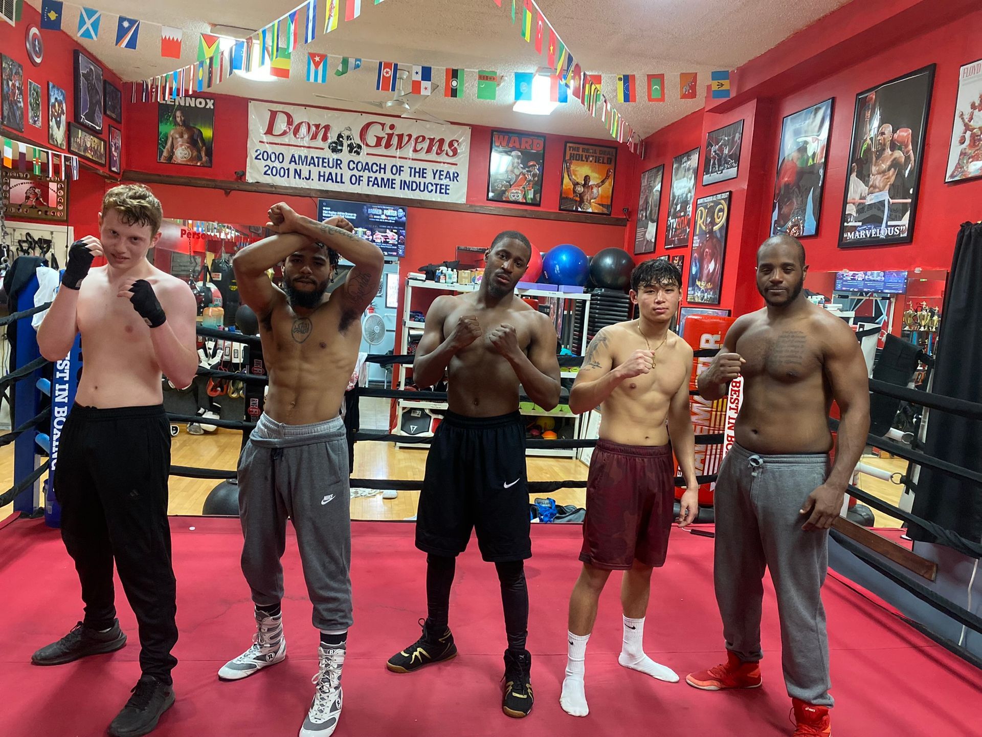 A group of men are posing for a picture in a boxing ring