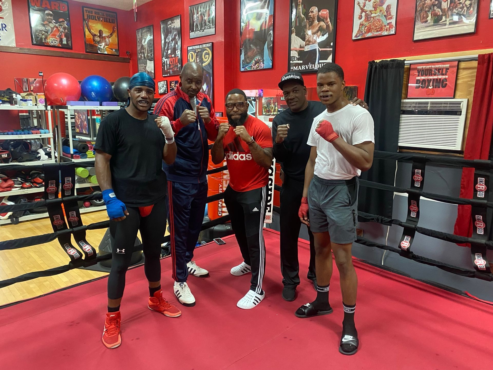 A group of men are posing for a picture in a boxing ring.