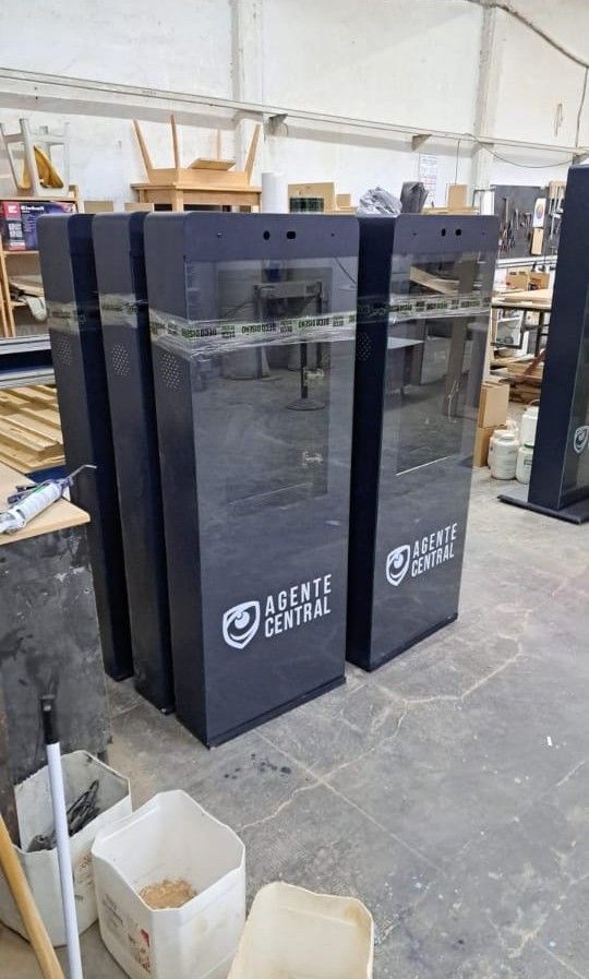 Quioscos oscuros con el logo de “Agente Central” en entorno de taller.