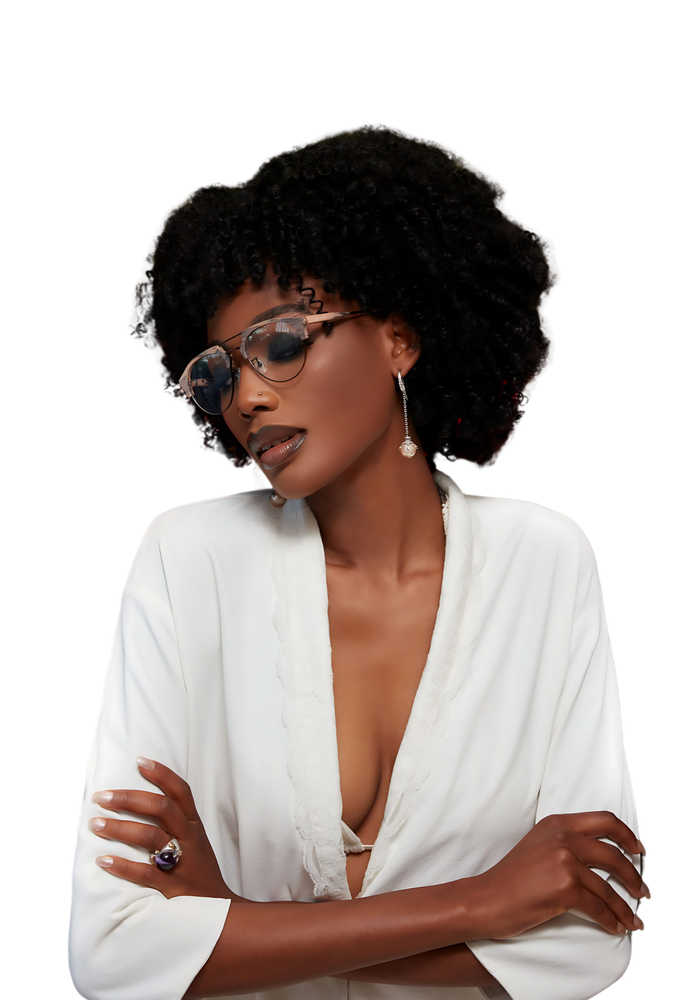 Person with curly hair and sunglasses, wearing a white top with arms crossed.