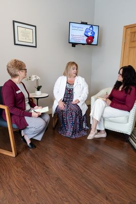 Dr. Christina Cocozzo in a morning huddle with two team members at Cocozzo Family Dentistry in Malta, NY