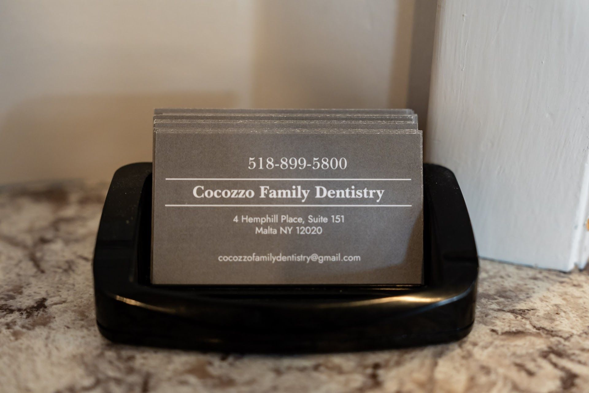 Cocozzo Family Dentistry business card at the front desk in Malta, NY