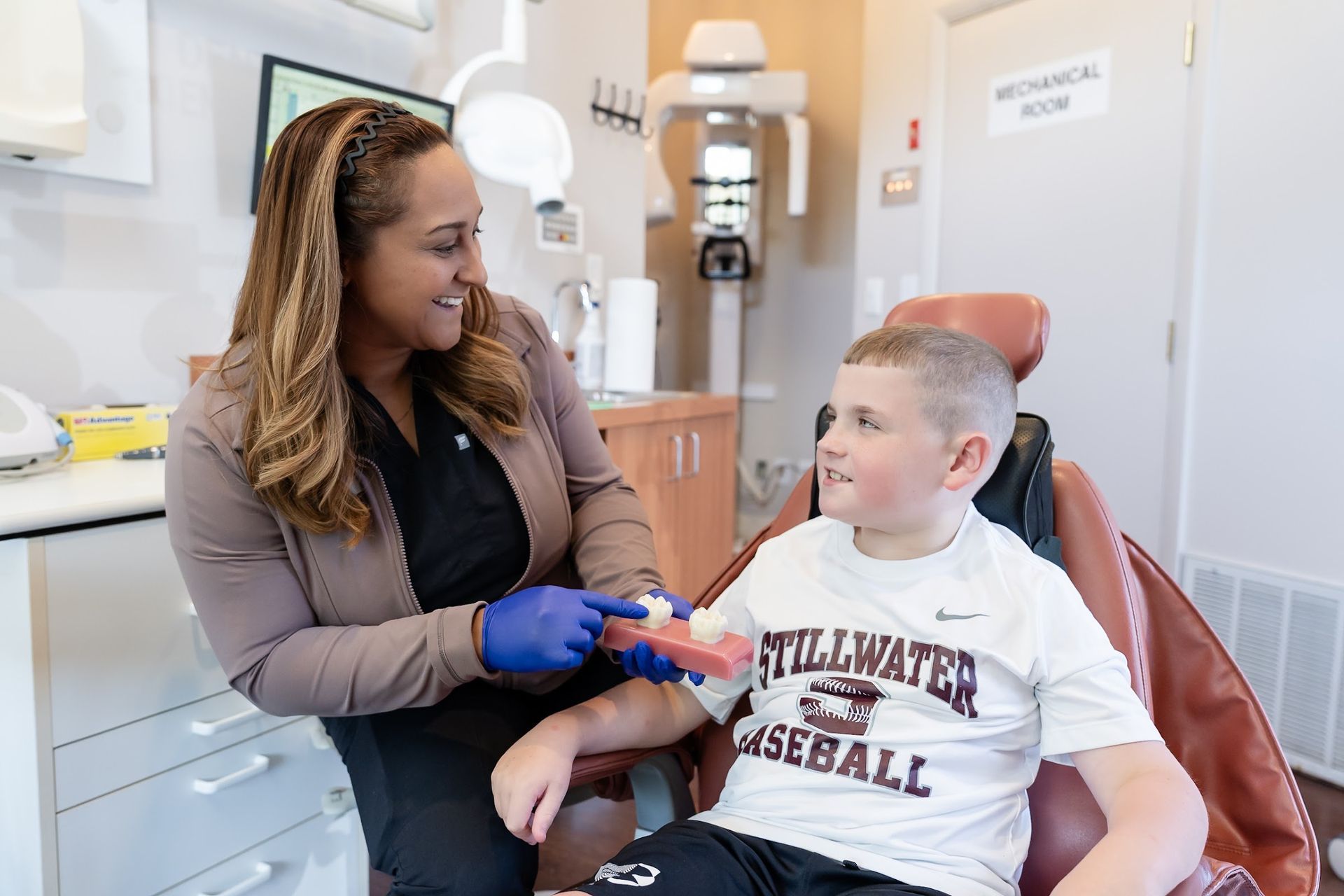 A Cocozzo team member showing a smiling young patient his care in Malta, NY