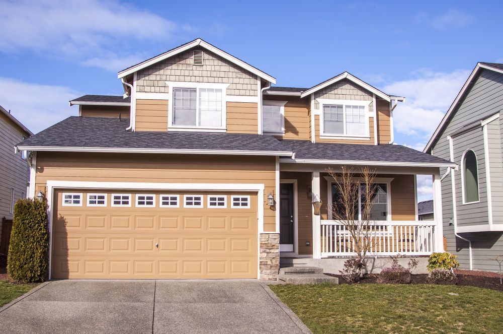 A House With a Large Garage Door and a Porch — Key2 Conveyancing In Pacific Palms, NSW