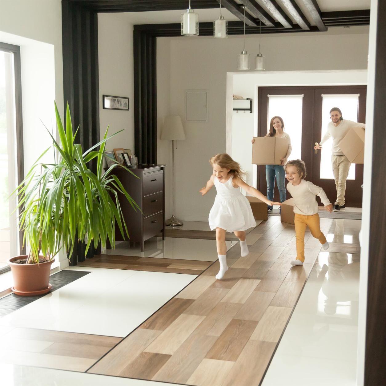 A Family is Moving Into a New Home and Two Children Are Running in the Living Room — Key2 Conveyancing In Forster, NSW