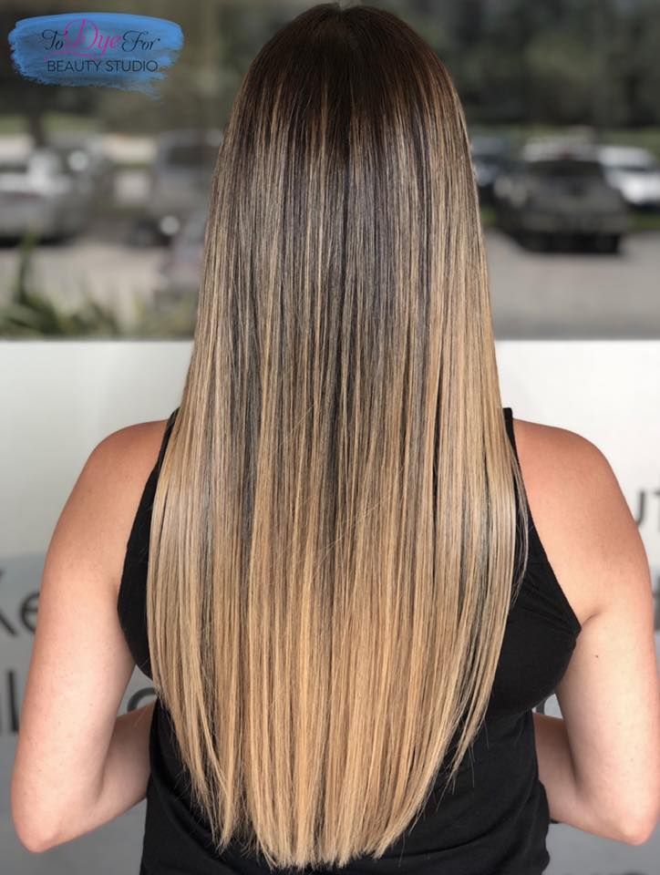 A woman with long hair is wearing a black tank top