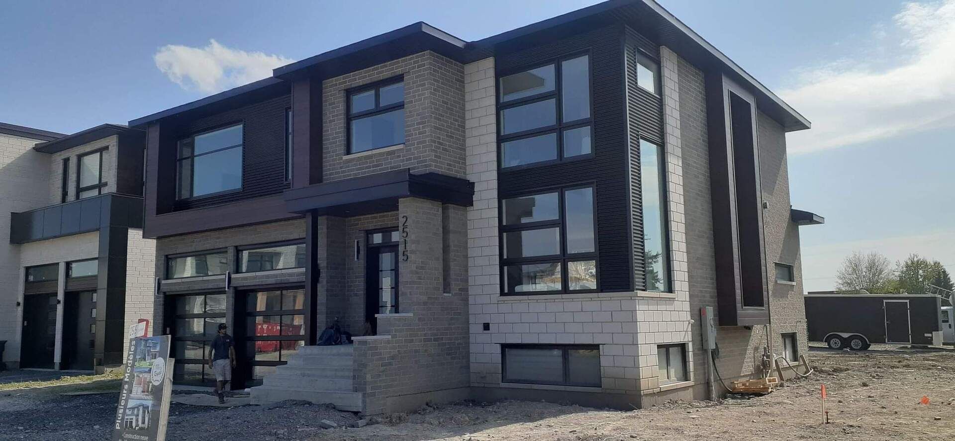 Une grande maison en briques avec beaucoup de fenêtres est en construction.