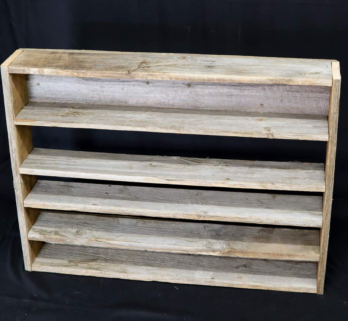 Une étagère en bois sur un fond noir