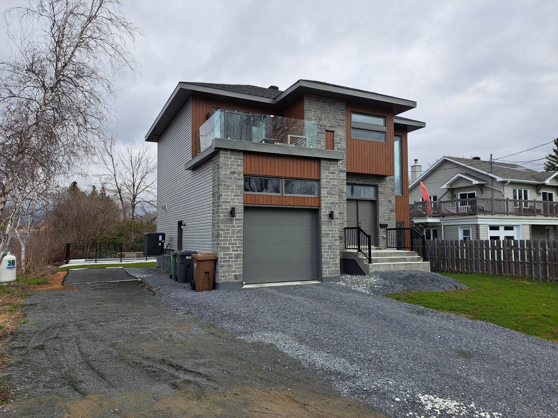 Une grande maison avec un garage et une allée devant.