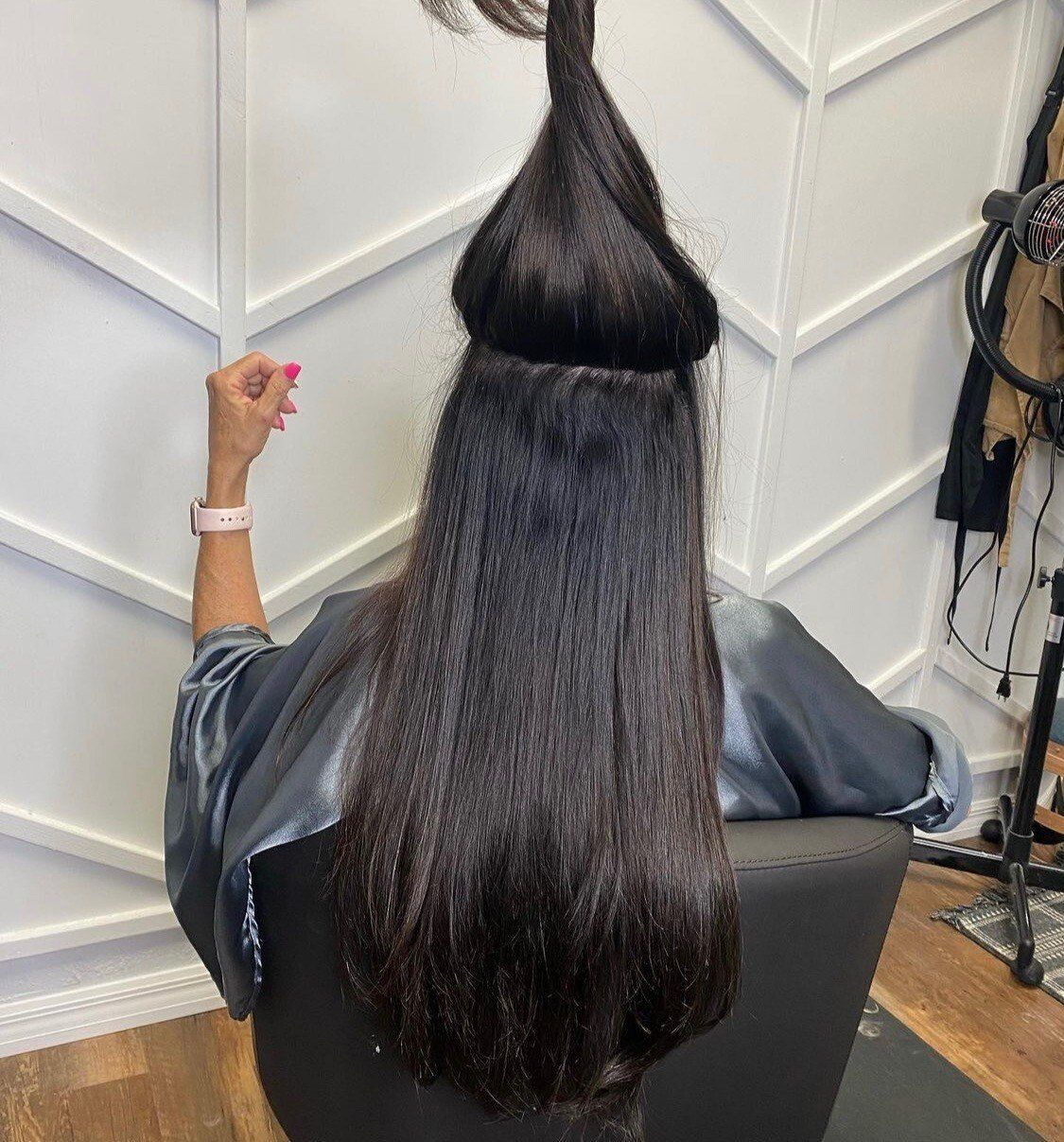 Blue 22 Salon & Spa Person with long dark hair pulled into a cone-shaped style, seated in a salon chair