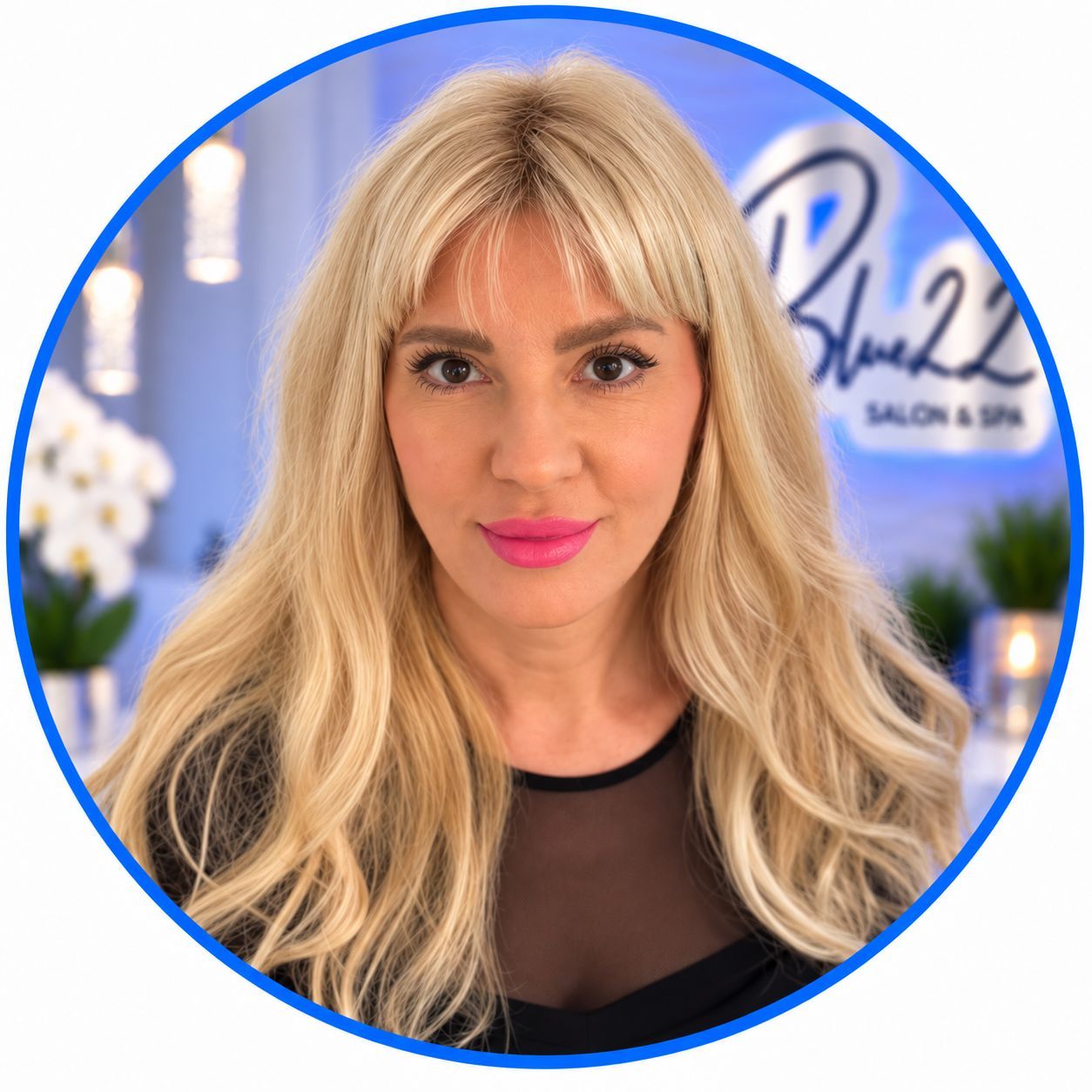 Blue 22 Salon & Spa Blonde woman with pink lipstick in a circular profile photo, standing before a salon sign.