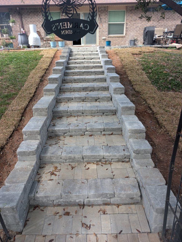 Stone steps leading up to a brick house entrance, with a hanging sign above the doorway.
