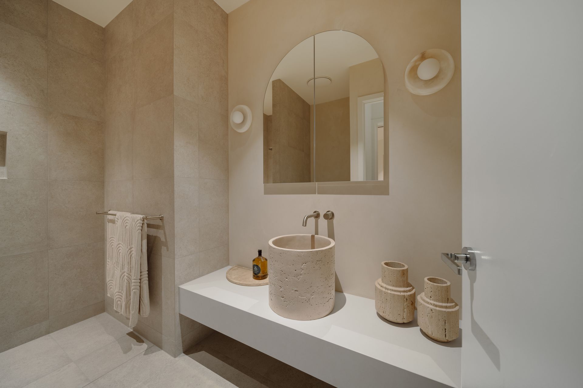 Beige Bathroom With A Vessel Sink, Arched Mirror, And Minimalist Decor — Simon Bell Constructions in Alice River, QLD