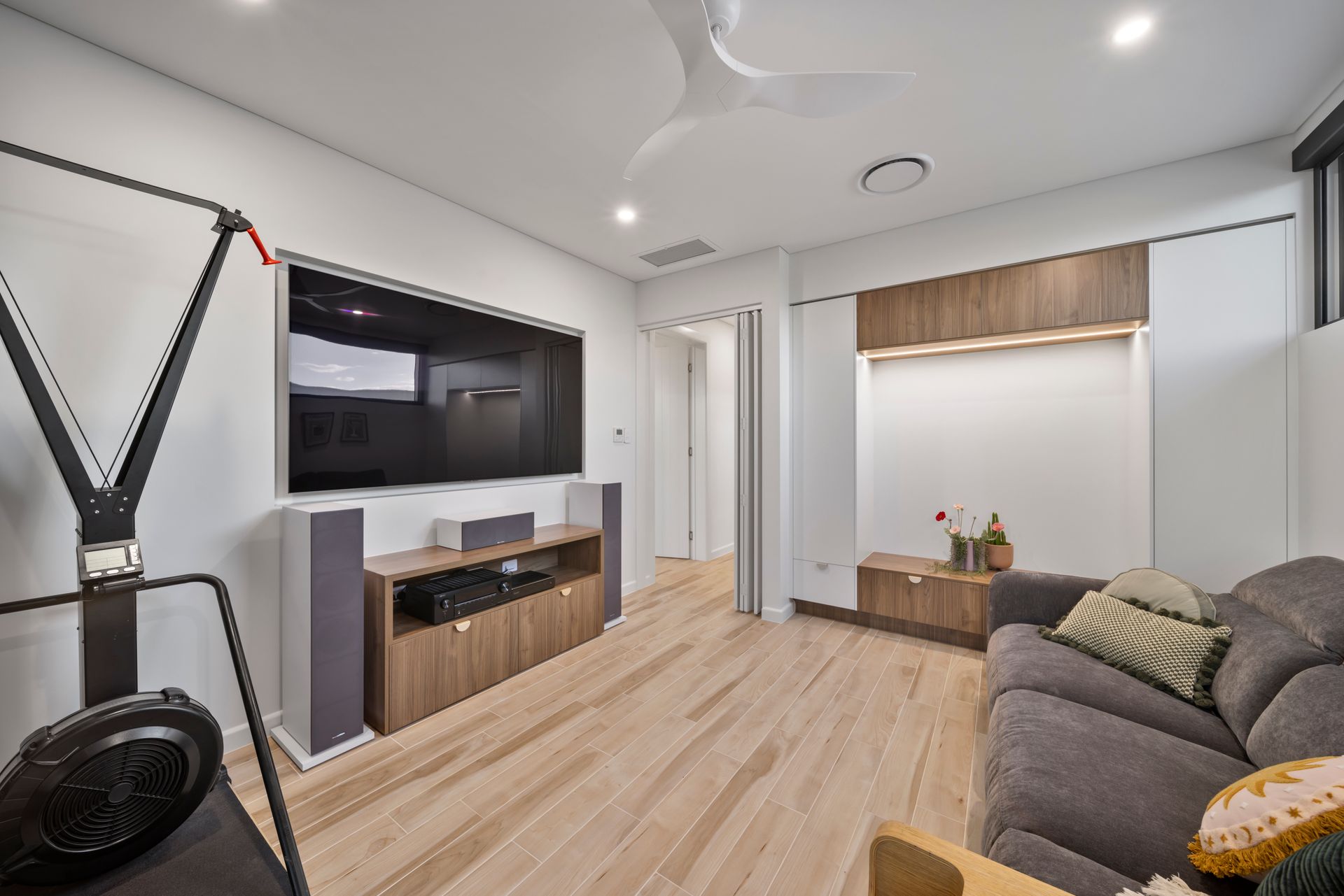 Modern Living Room With Wall-mounted TV, Wooden Floor, Gray Sofa — Simon Bell Constructions in Alice River, QLD