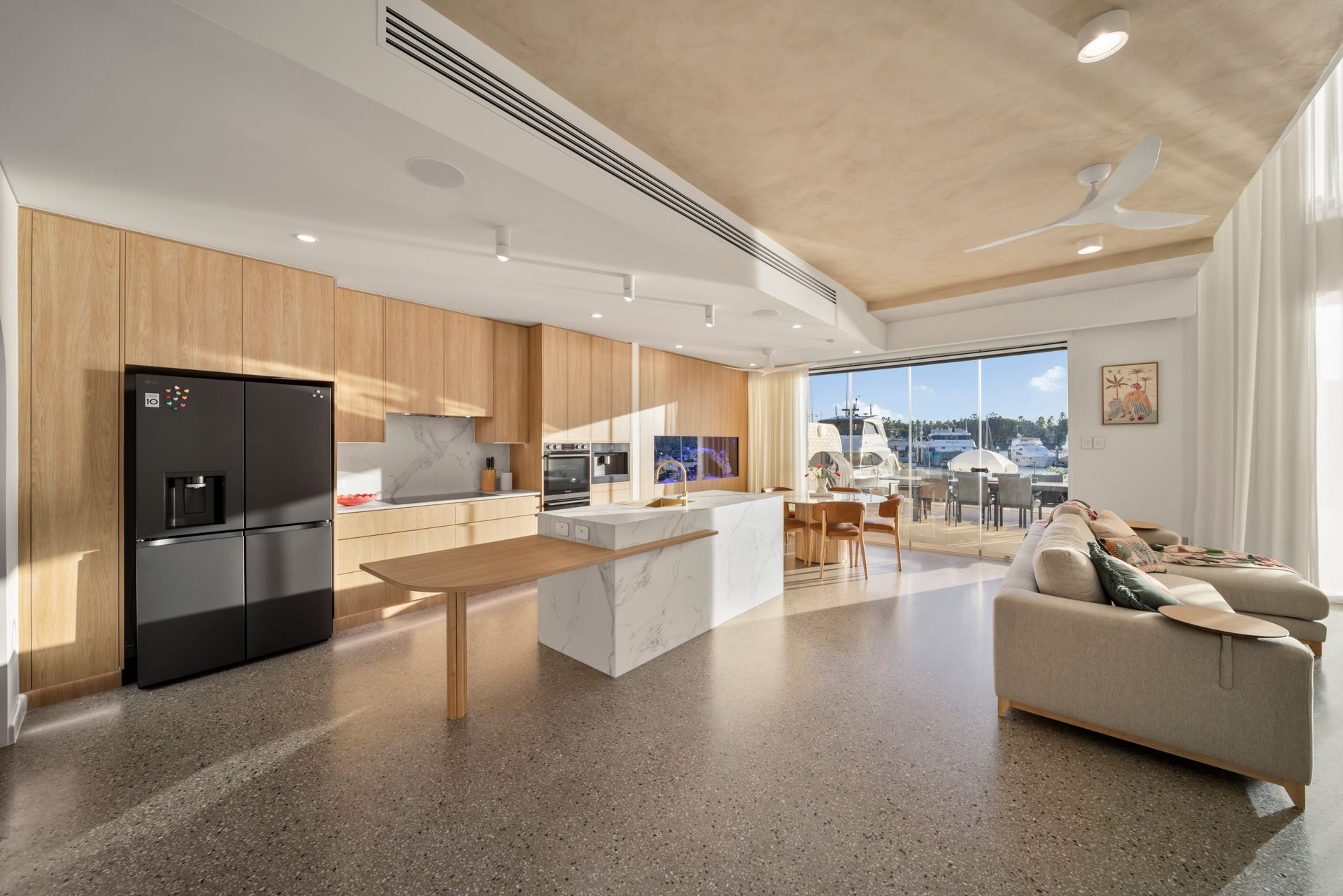 Modern Open-plan Kitchen and Living Room With Black Fridge — Simon Bell Constructions in Alice River, QLD