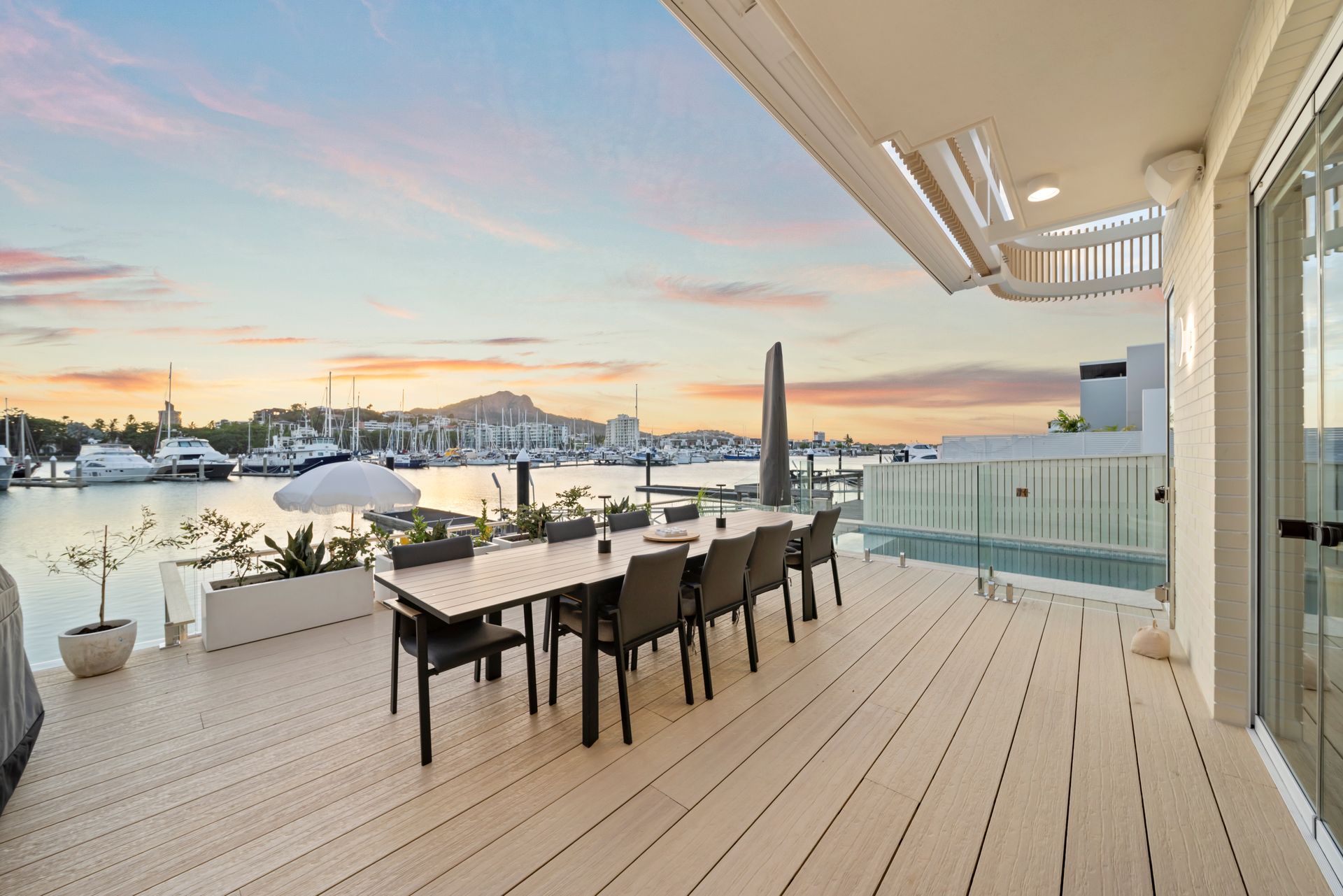 Spacious Waterfront Deck at Sunset With Dining Table — Simon Bell Constructions in Alice River, QLD