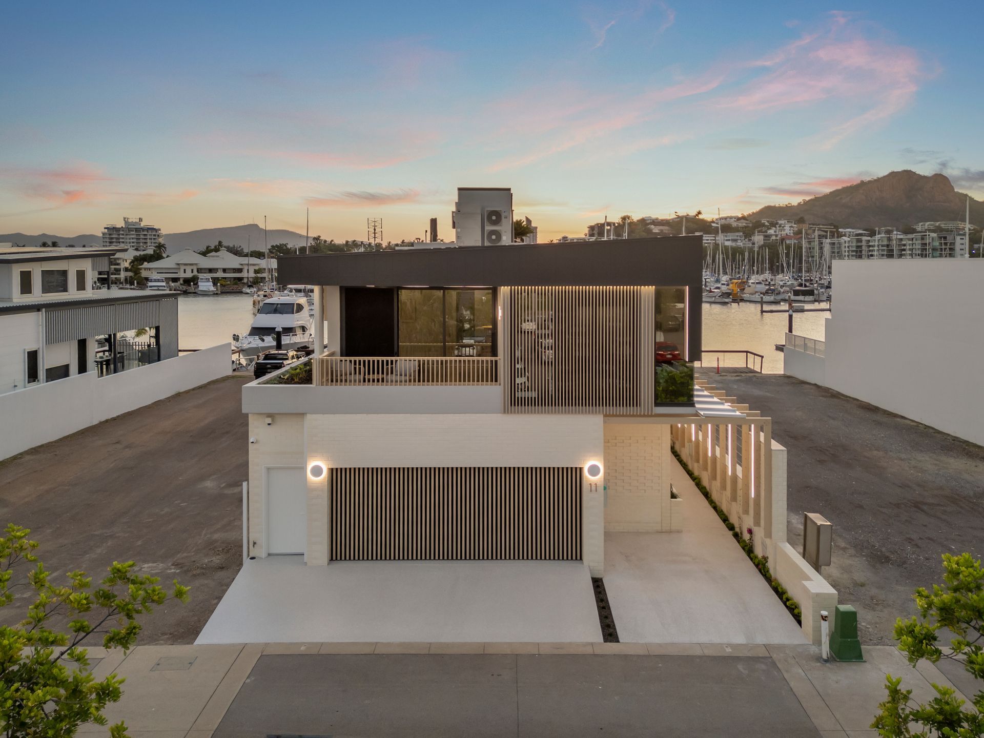 Modern Two-story House With a Rooftop Terrace in a Suburban Neighborhood at Sunset — Simon Bell Constructions in Alice River, QLD