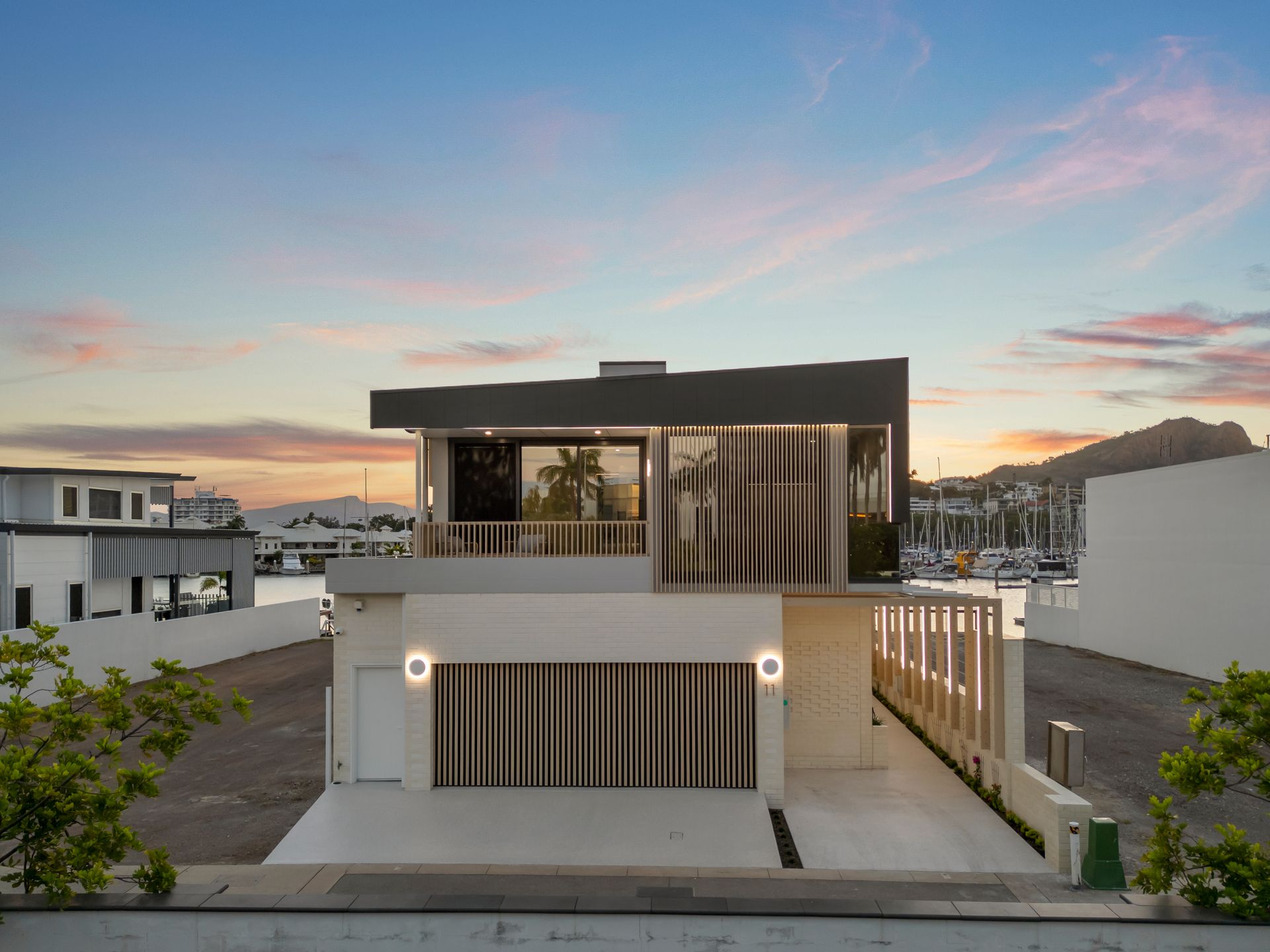 Modern Two-story House With Large Windows at Sunset — Simon Bell Constructions in Alice River, QLD