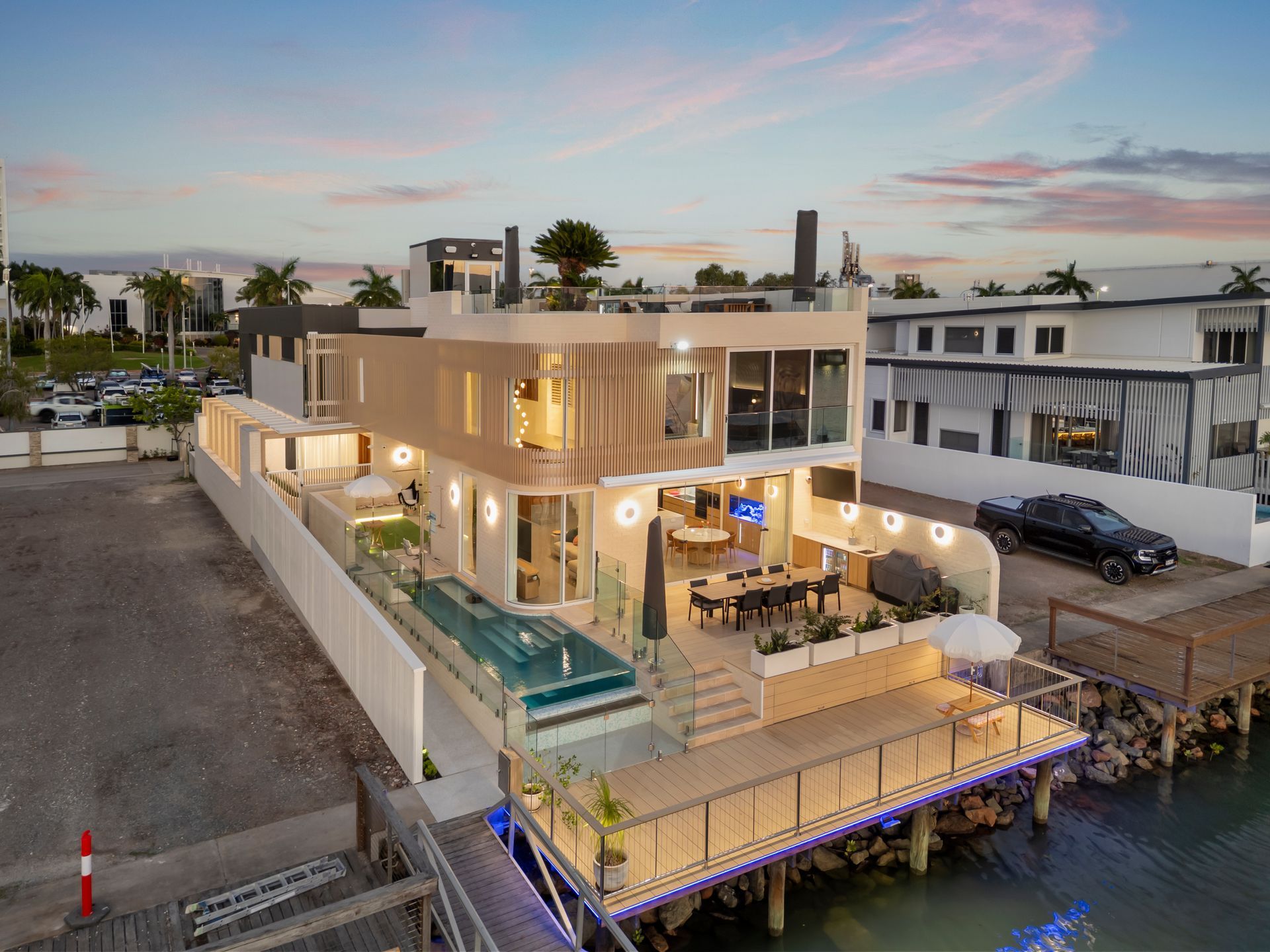 Modern Waterfront House at Dusk With Lit Patio — Simon Bell Constructions in Alice River, QLD
