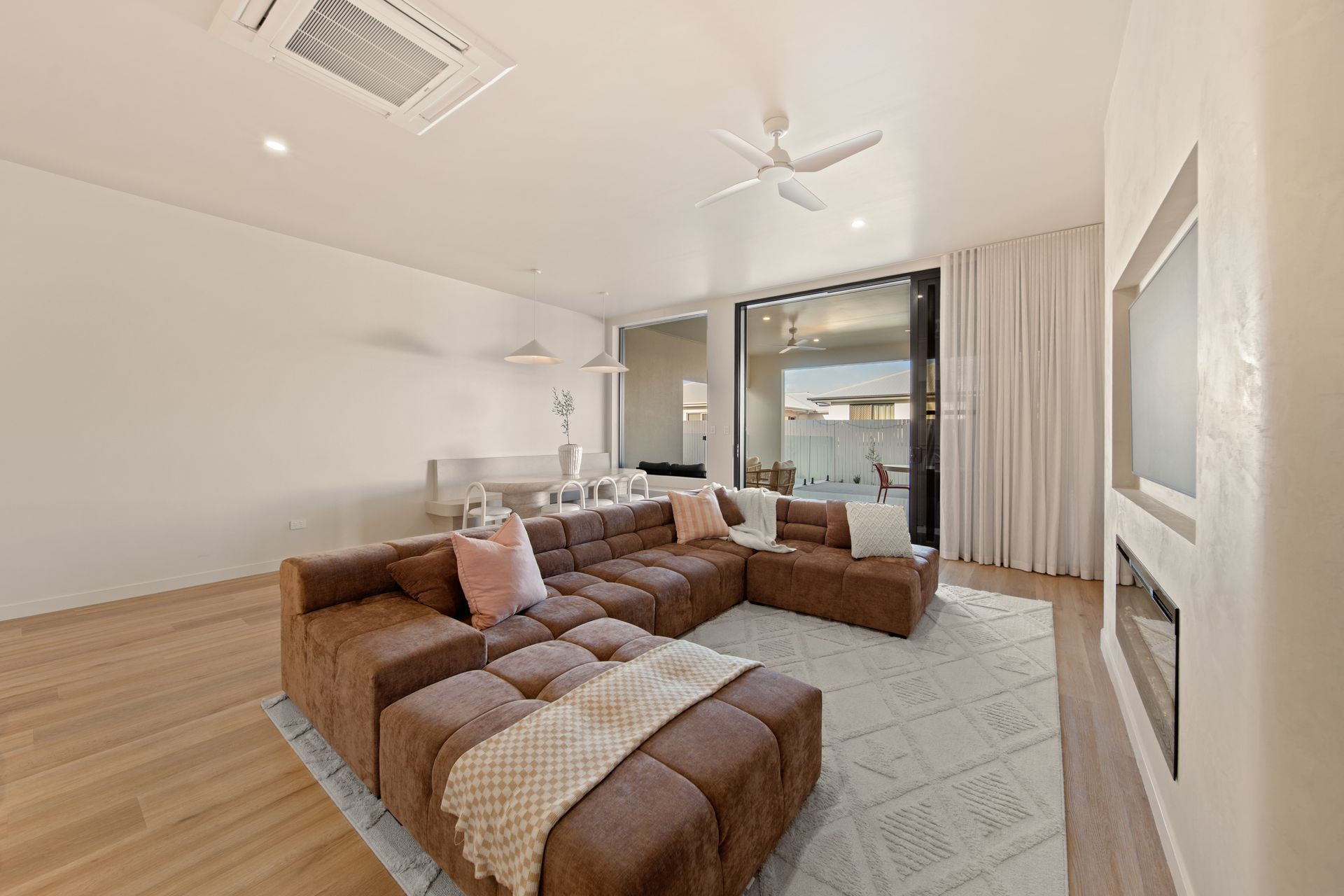 Bright Living Room With Brown Sectional Sofa, Light Rug — Simon Bell Constructions in Alice River, QLD