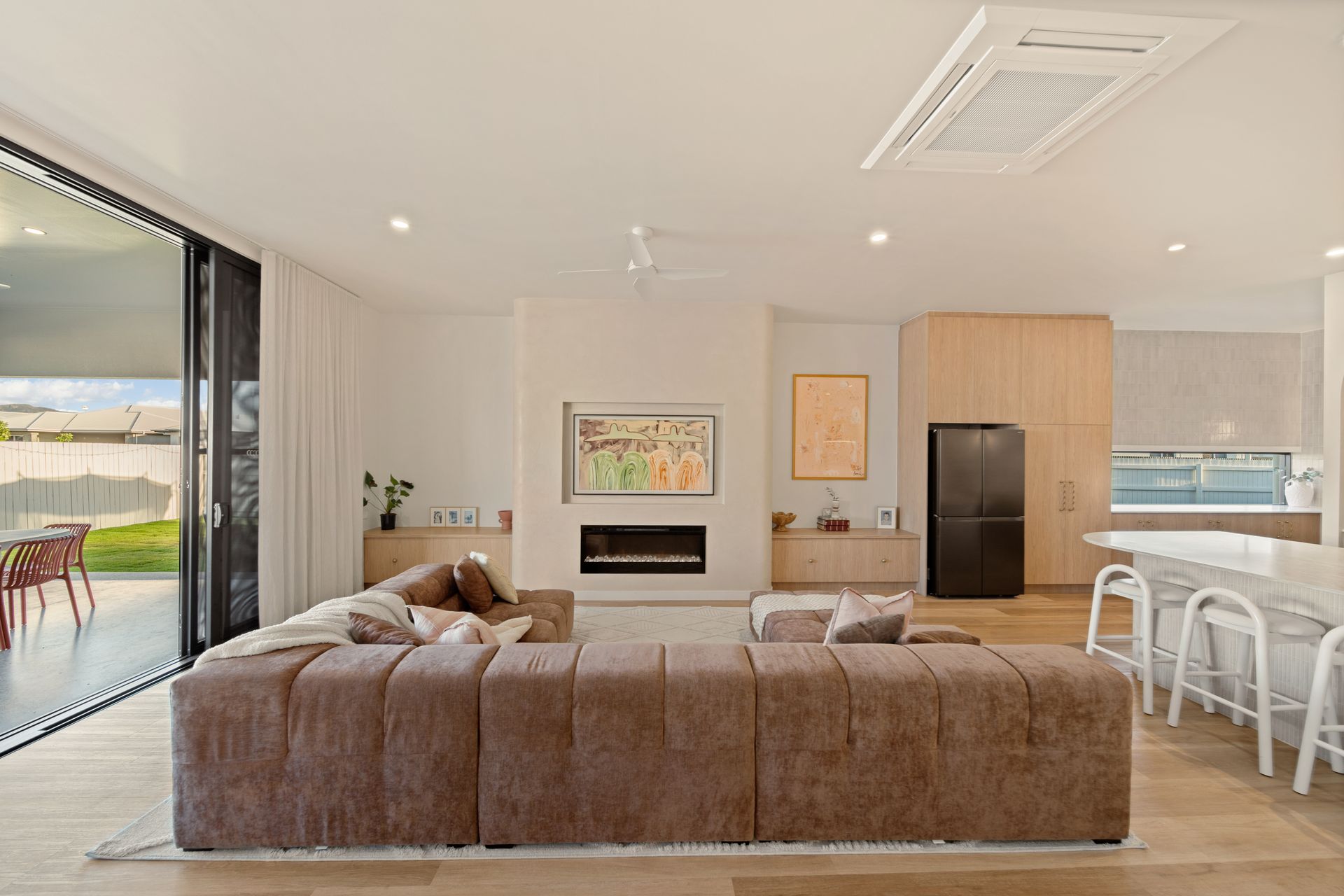 Bright Open-Plan Living Room With Brown Sectional — Simon Bell Constructions in Alice River, QLD