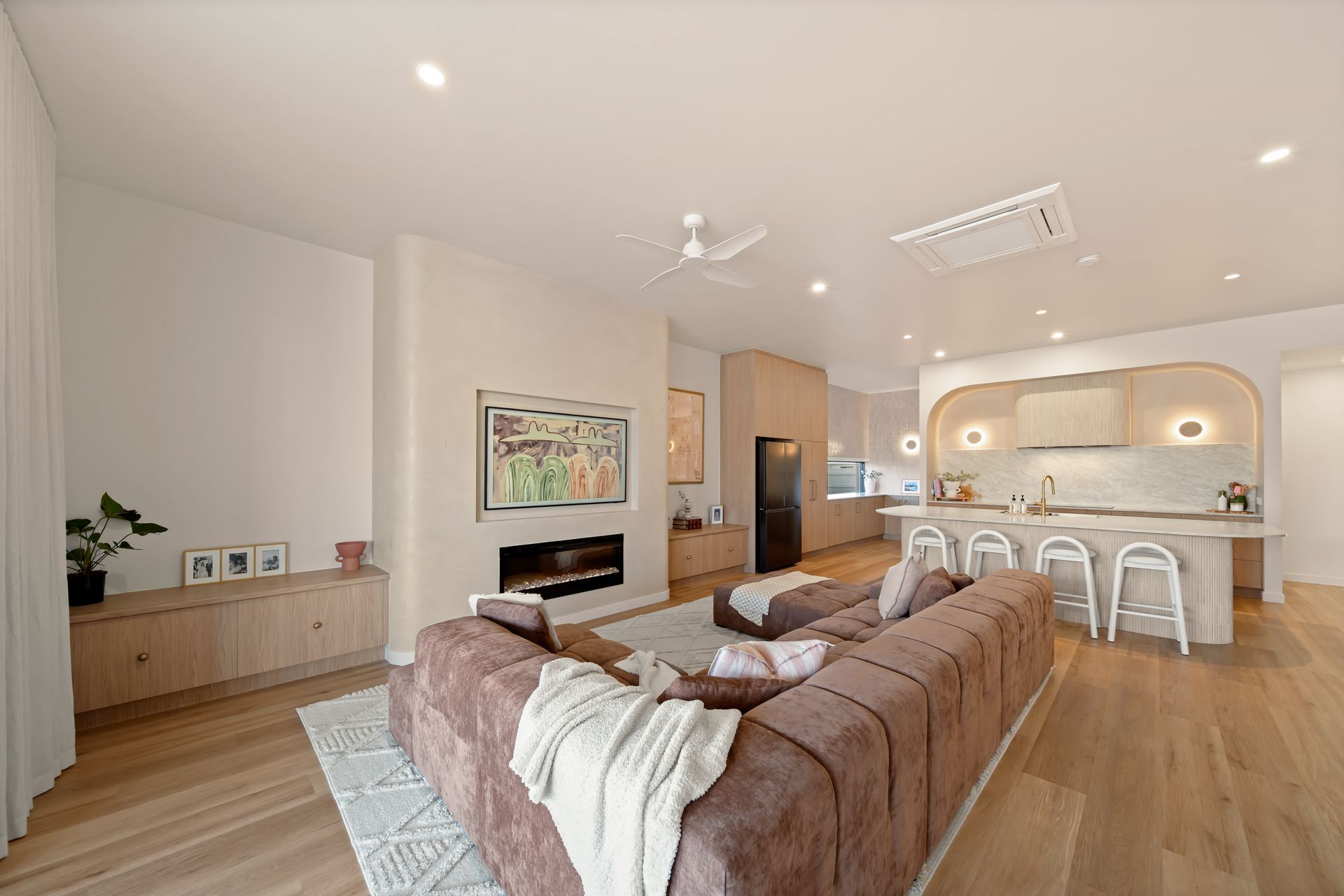 Modern Open-concept Living Room With Beige Sofa, Fireplace, Wood Floors — Simon Bell Constructions in Alice River, QLD