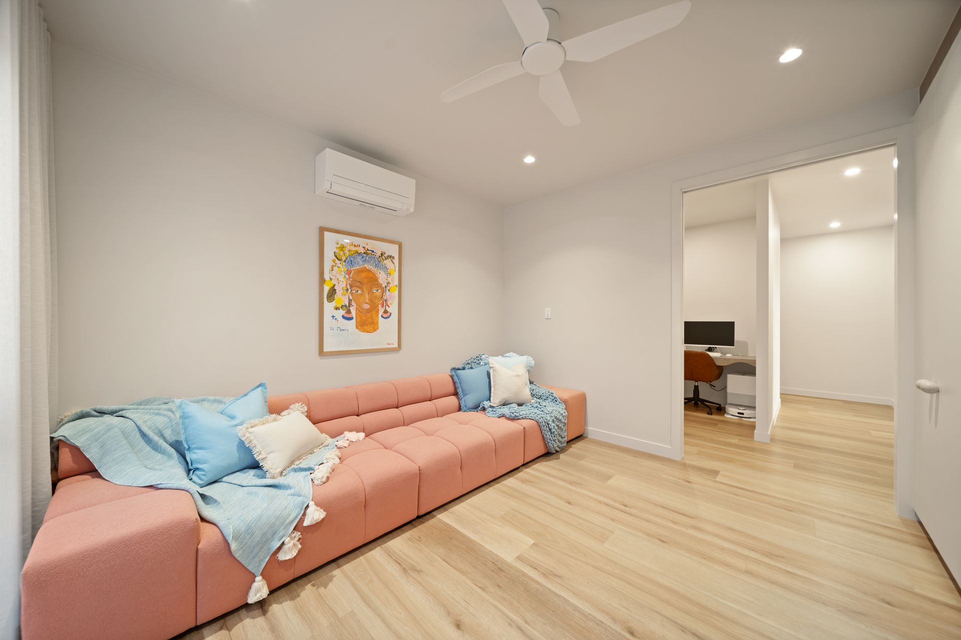 Bright Living Room With Pink Sectional Sofa, Blue Pillows, Wood Floor — Simon Bell Constructions in Alice River, QLD