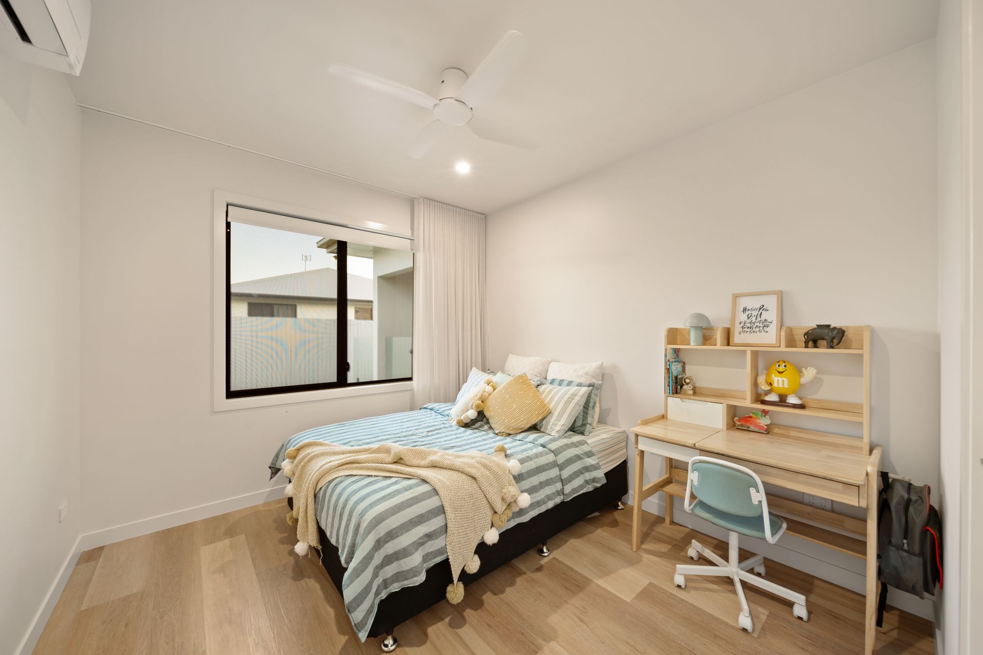 Bright Bedroom With a Bed, Desk, Chair, and Window — Simon Bell Constructions in Alice River, QLD