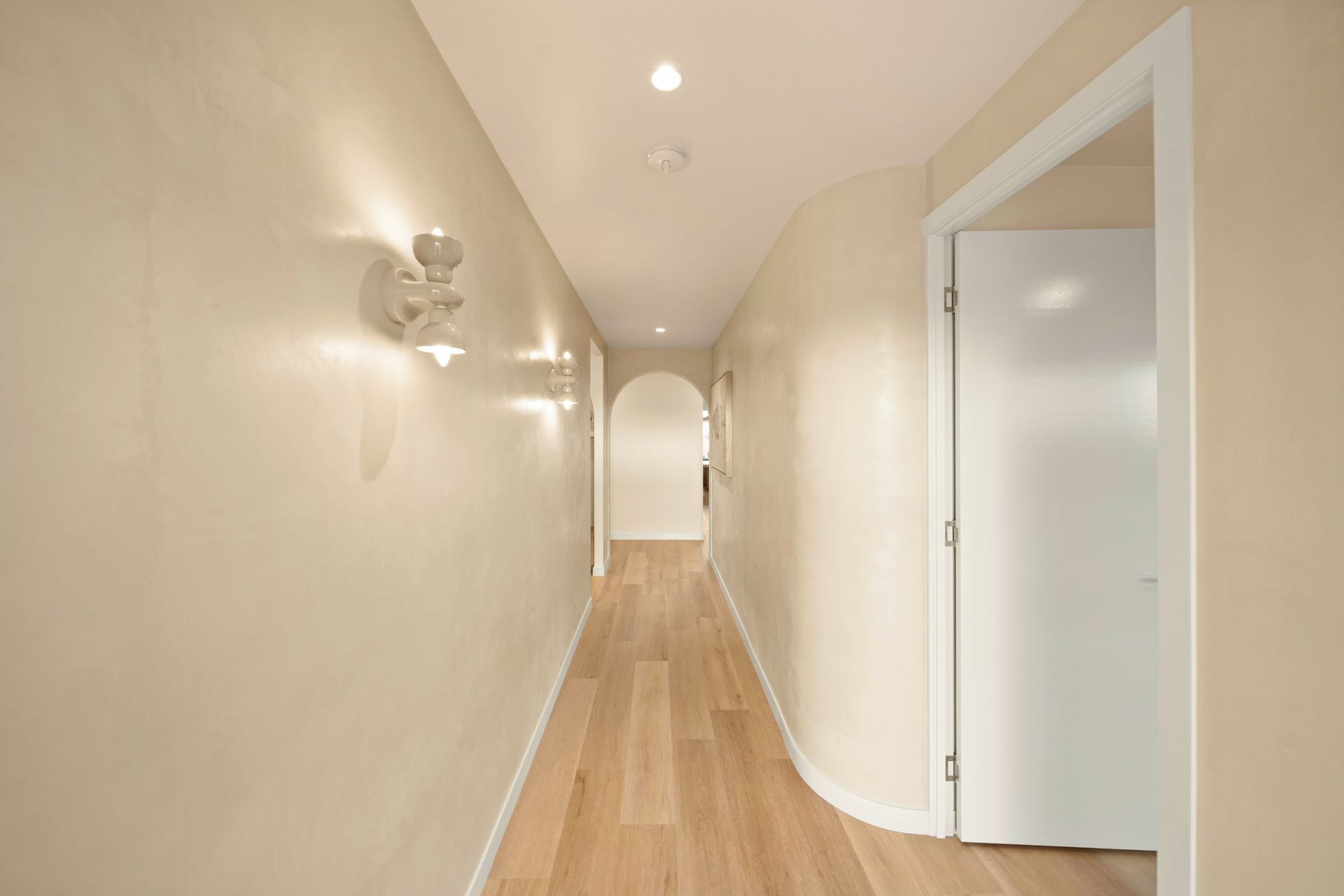 Narrow Beige Hallway With Wood Floor, Wall Sconces — Simon Bell Constructions in Alice River, QLD