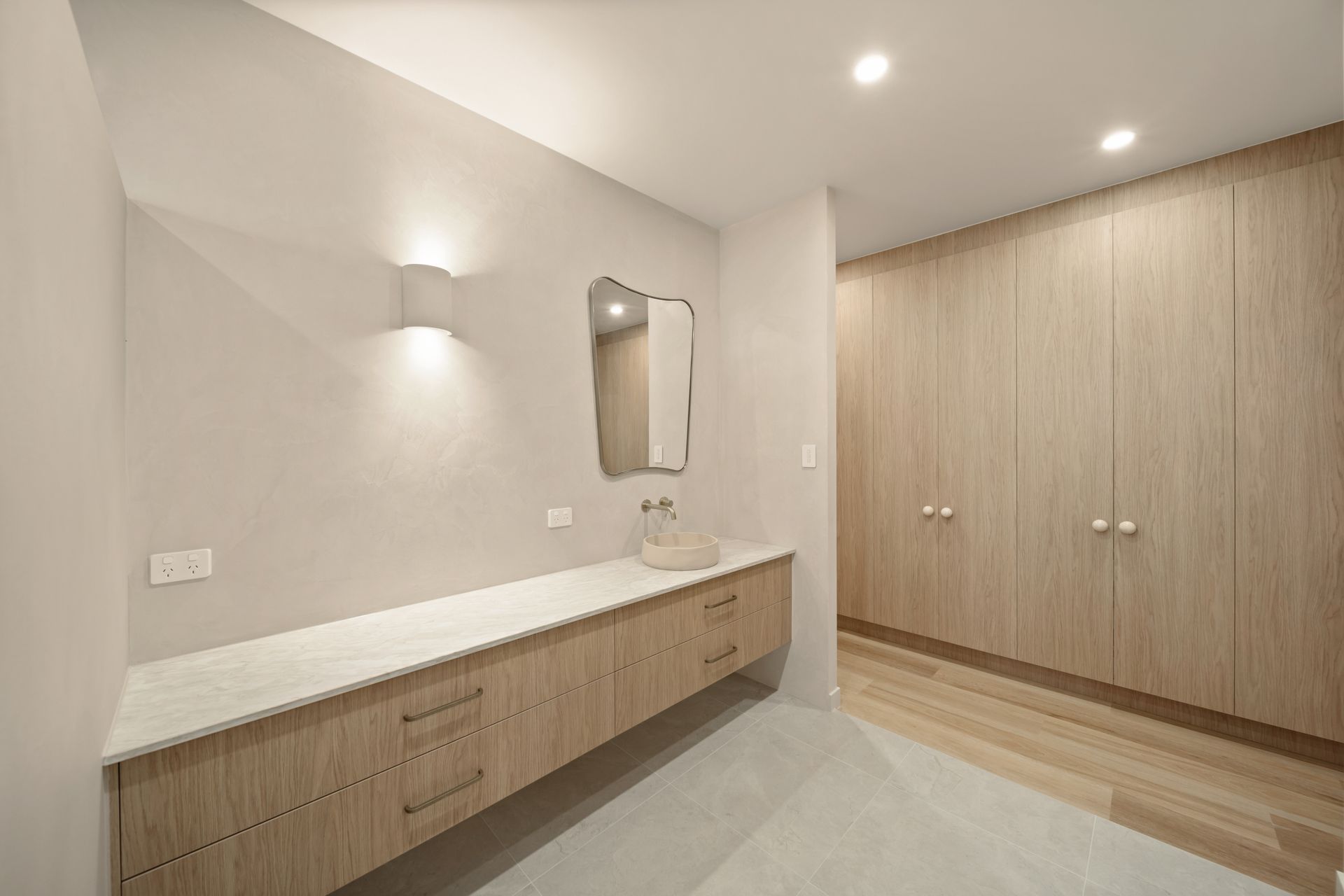 Modern Bathroom Vanity With Wood Cabinets, White Countertop, Wall Sconces — Simon Bell Constructions in Alice River, QLD