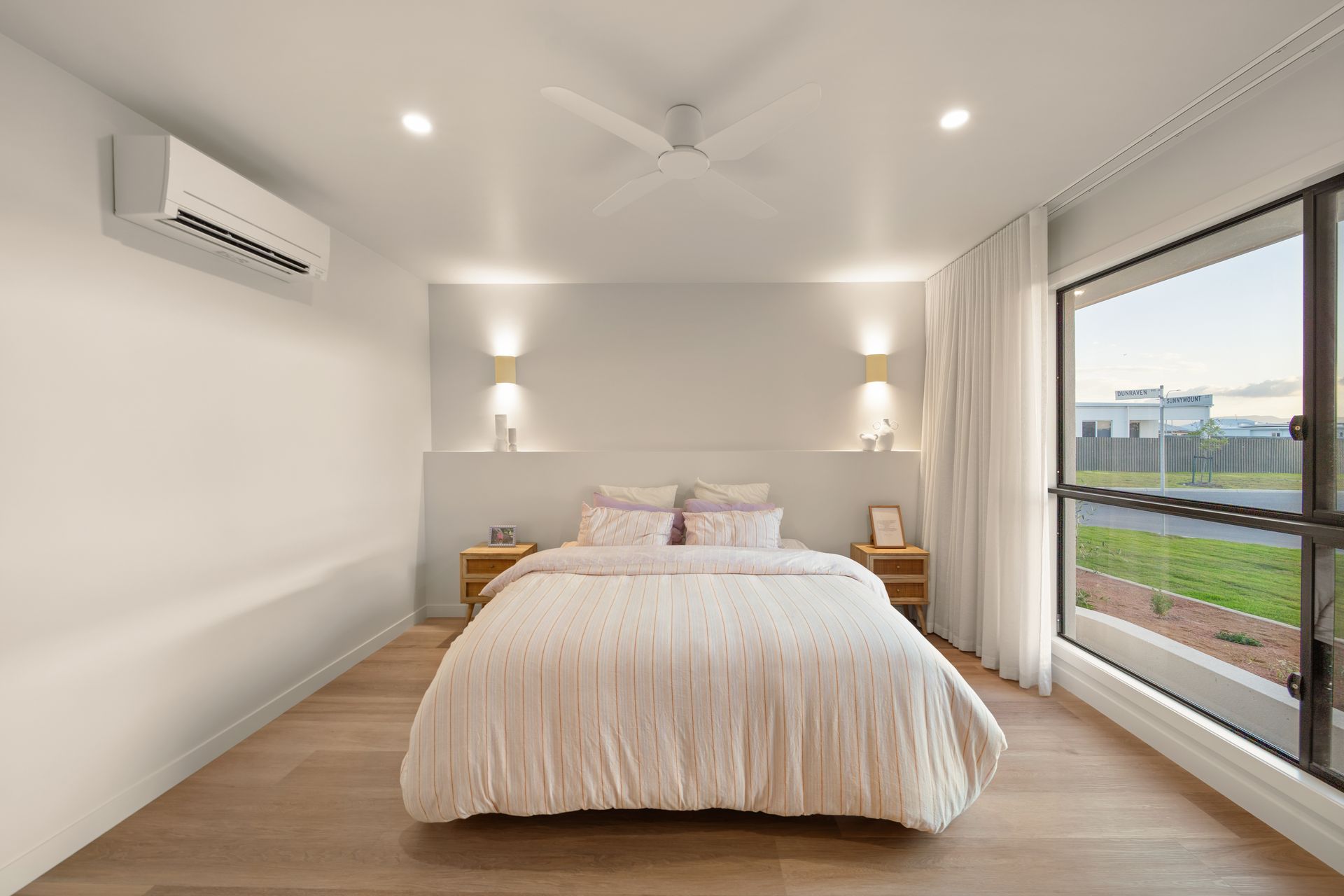 Modern Bedroom With a Large Bed, White Walls, Wood Floor — Simon Bell Constructions in Alice River, QLD