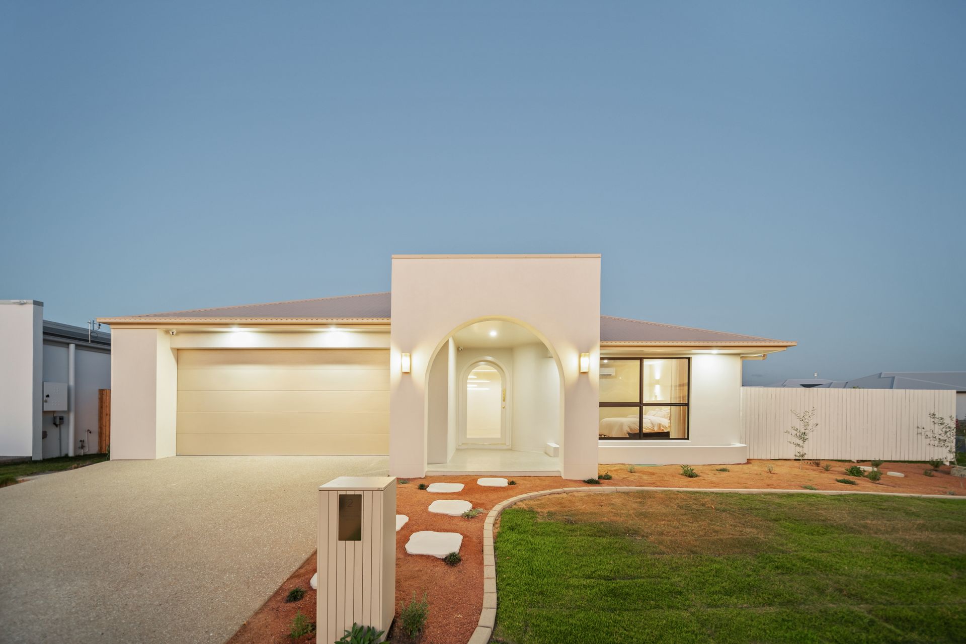 Modern Single-story House at Dusk With Lit Entryway, Garage — Simon Bell Constructions in Alice River, QLD