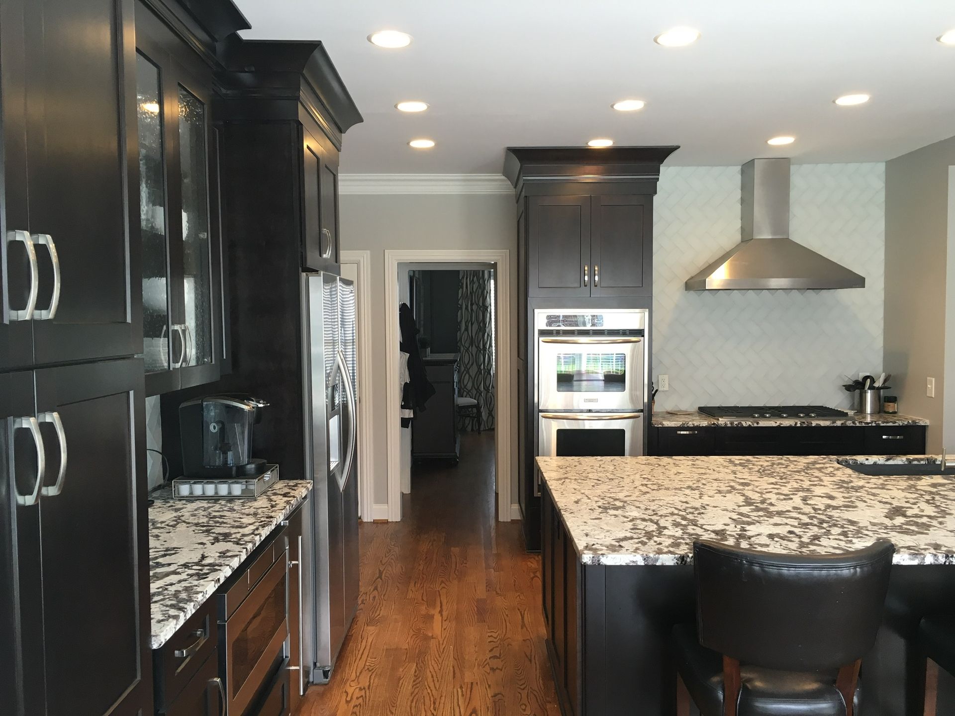a kitchen with black cabinets and granite counter tops