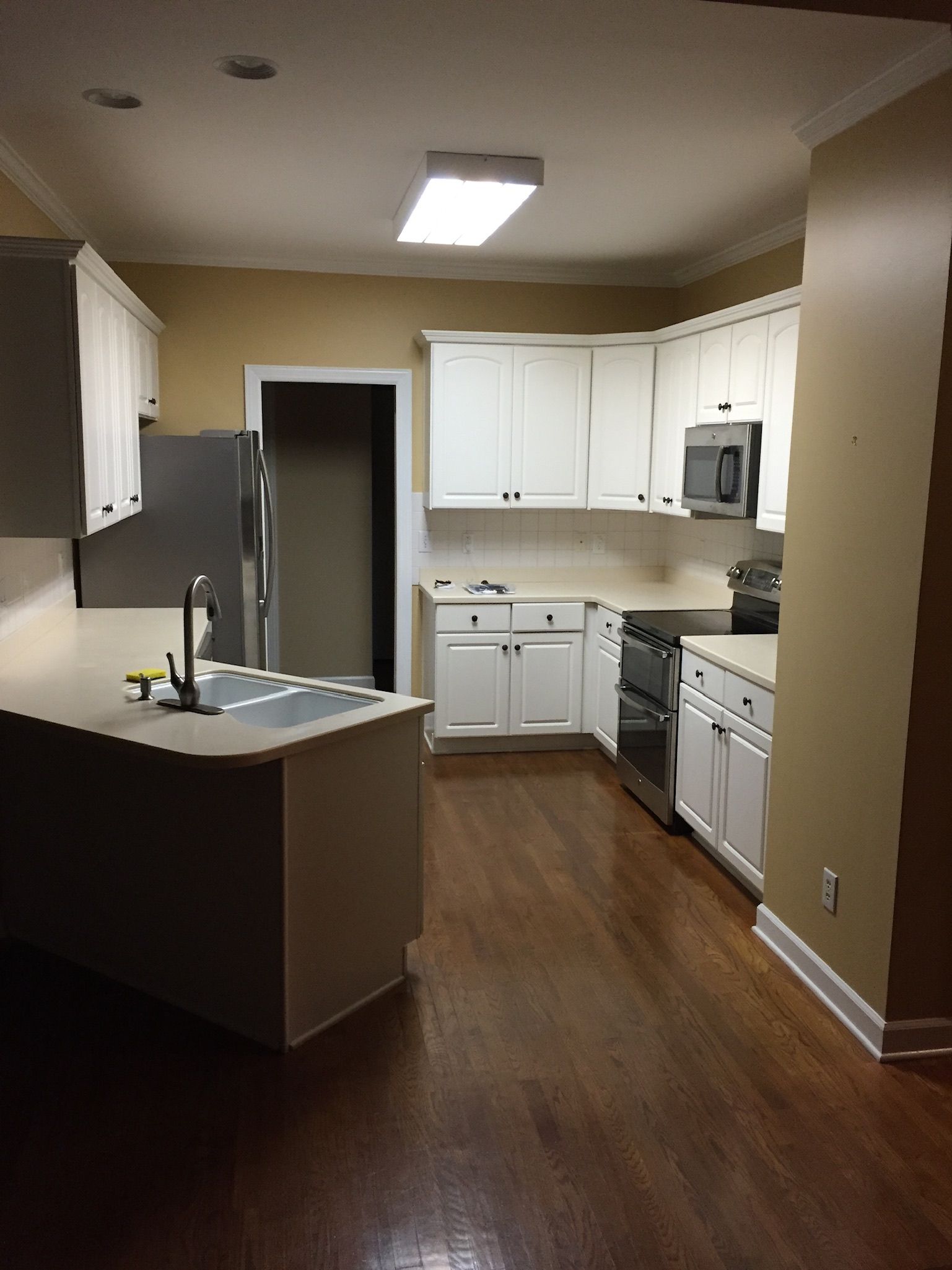 a kitchen with white cabinets and stainless steel appliances