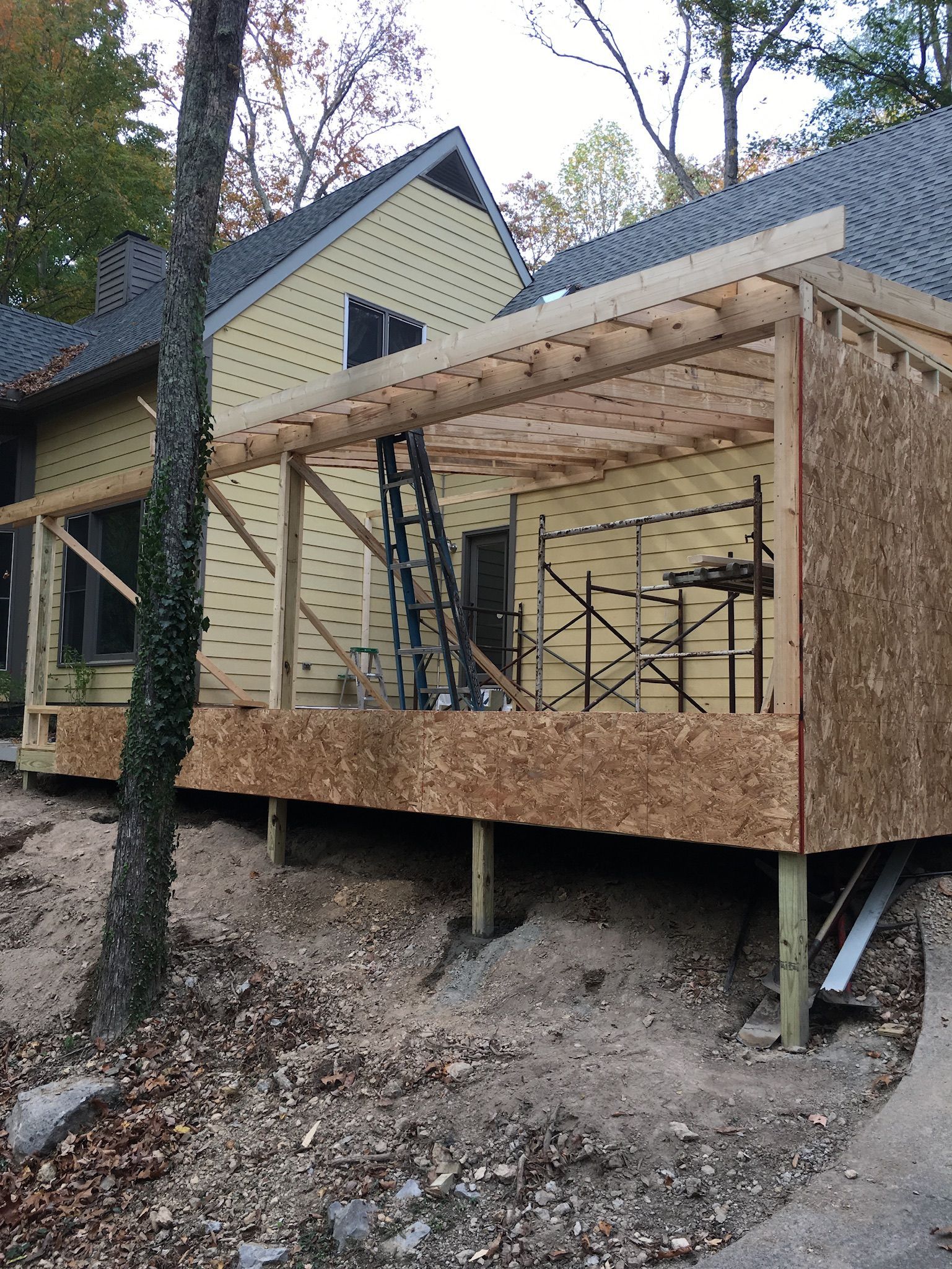 a house is being built on stilts in the woods