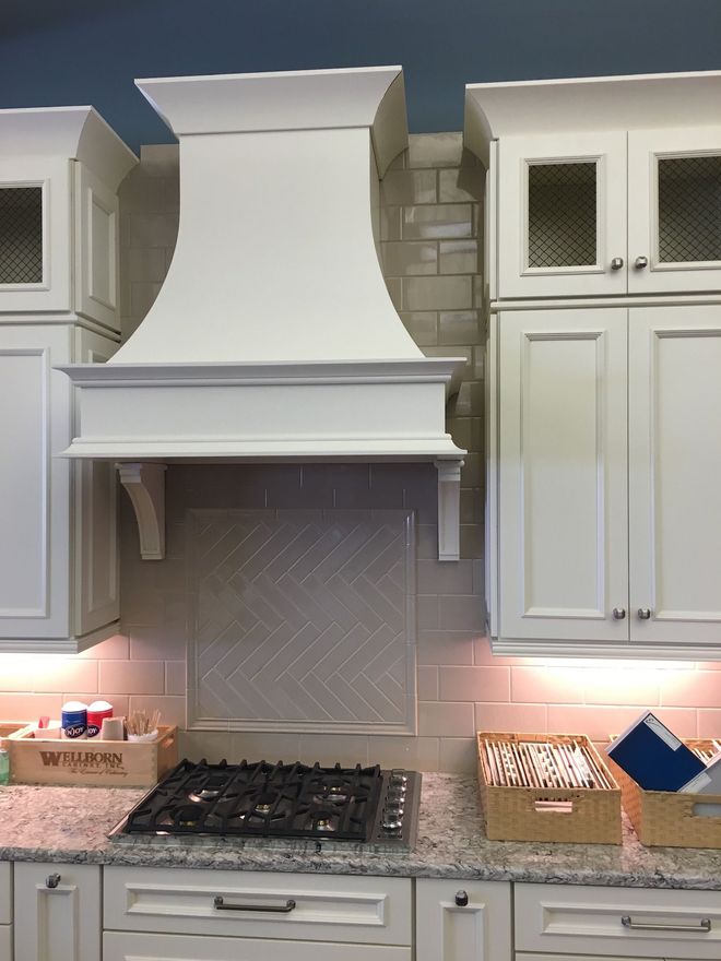 a kitchen with white cabinets and a stove top oven