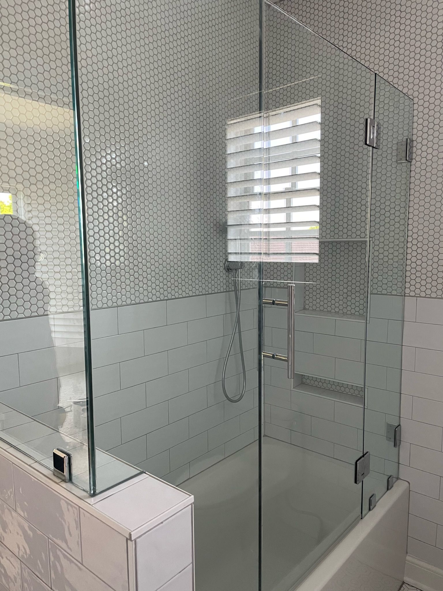 a bathroom with a glass shower door and a bathtub